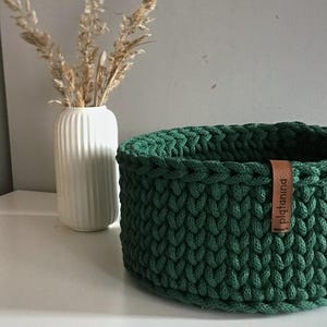Una cesta decorativa tejida, un recipiente para guardar objetos pequeños, un elemento decorativo en un estante de una habitación o baño. imagen 9