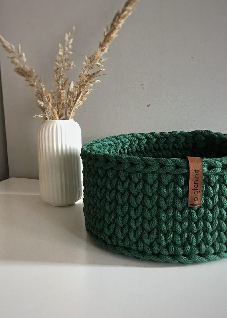 Una cesta decorativa tejida, un recipiente para guardar objetos pequeños, un elemento decorativo en un estante de una habitación o baño. imagen 9