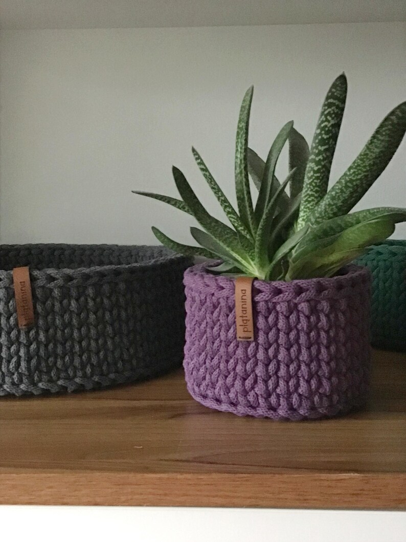 Una cesta decorativa tejida, un recipiente para guardar objetos pequeños, un elemento decorativo en un estante de una habitación o baño. imagen 4