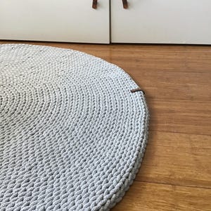 Thin and soft rug, woven on crochet carpet with a simple pattern, a floor decoration of any interior.