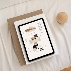 Pode incluir: Um tablet digital exibindo um conceito de design "Paleta de Materiais", repousando sobre uma pilha de livros. A tela do tablet mostra v&aacute;rias texturas e amostras de cores. Uma esfera de madeira est&aacute; pr&oacute;xima em uma superf&iacute;cie branca.