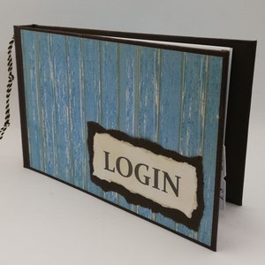 Könnte beinhalten: Ein braunes und blaues Notizbuch mit einem verwitterten Holzmaserungsmuster. Der Einband hat ein zerrissenes Papieretikett mit dem Wort "LOGIN" in Schwarz gedruckt.