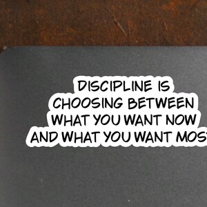 May include: A black and white motivational quote on a gray background. The quote reads "Discipline is choosing between what you want now and what you want most."