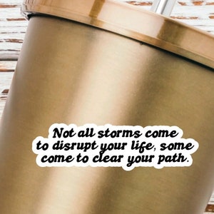 May include: A gold tumbler with a white sticker that reads "Not all storms come to disrupt your life, some come to clear your path."