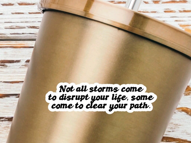 May include: A gold tumbler with a white sticker that reads "Not all storms come to disrupt your life, some come to clear your path."