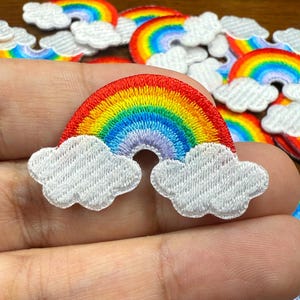 Può includere: Toppe arcobaleno ricamate con dettagli di nuvole bianche. L'arcobaleno presenta colori vivaci: rosso, arancione, giallo, verde, blu e viola. Queste toppe sono ideali per aggiungere un tocco di colore a vestiti o accessori.