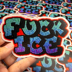 May include: A sticker featuring the phrase "FUCK ICE" in a beaded design. The letters are crafted from blue, green, and purple beads, outlined in black and red. The sticker is held by a hand.