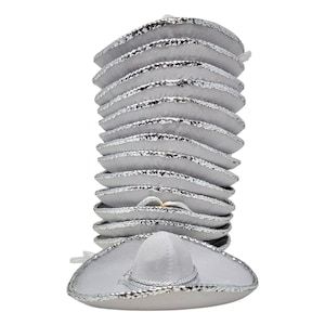 May include: A vertical stack of twelve white miniature sombrero hats, each featuring a rounded crown and a wide brim. The edges of every hat are trimmed with a reflective silver metallic material that catches the light.
