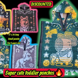 Może przedstawiać: Kolekcja małych ponczo dla maluchów z różnymi wzorami zwierząt i kowbojów. Ponczo są zielone, czarne i fioletowe, z frędzlami u dołu. Tekst na zdjęciu głosi "Super cute toddler ponchos" i "Discounted". Ponczo mają 43 x 86 cm długości.