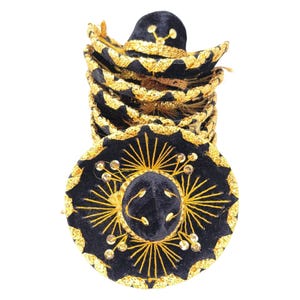 Op de afbeelding: Een stapel kleine zwarte fluwelen sombrero's met gouden metallic borduursels en lovertjes. Elke hoed heeft een brede rand met een geschulpte rand en een centrale kroon, versierd met stralende gouddraadpatronen en kleine ronde lovertjes.