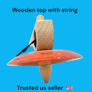 Könnte beinhalten: Ein Holz-Kreisel mit einer rot-braunen Basis und einem Holz-Oberteil mit einer daran befestigten schwarzen Schnur.
