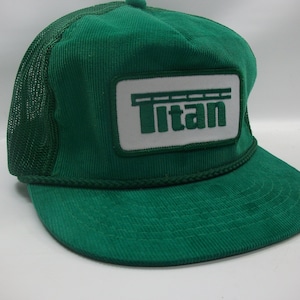 May include: Green corduroy trucker hat with a white patch that says "Titan" and a black bridge graphic above the text.