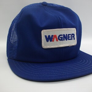 May include: Blue and white trucker hat with a white patch that says "WAGNER" in red and blue lettering.