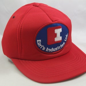 May include: Red baseball cap with a blue and red patch that says "Earl's Industries Ltd."