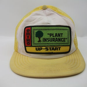 May include: Yellow and white trucker hat with a green, red and yellow patch that says "Ortho "Plant Insurance" Up-Start"