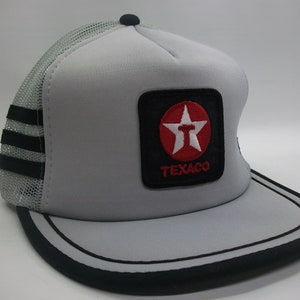 May include: A gray and black trucker hat with a red star and the word "TEXACO" in white lettering.