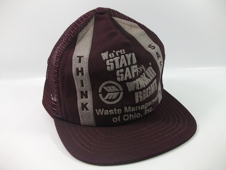May include: A burgundy and gray trucker hat with the text "Think" on the left side and "We're Stayin' Safe by Workin' Right Waste Management of Ohio, Inc." on the right side.