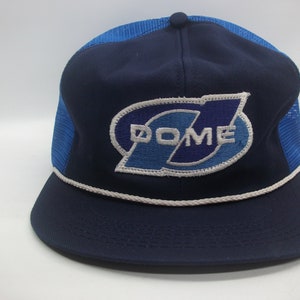 May include: A blue and white mesh trucker hat with a white rope trim and a blue and white embroidered logo that says "DOME".