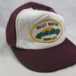 May include: A white and maroon trucker hat with a patch that says "Valley Roofing Sonoma, Calif." with a graphic of mountains and a sun.