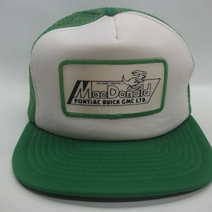 May include: A green and white trucker hat with a white patch that says "MacDonald Pontiac Buick GMC LTD." and features a cartoon kangaroo. The hat has a green mesh back.