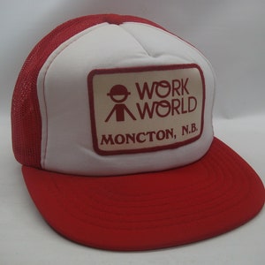 May include: Red and white trucker hat with a red patch that says "Work World" and "Moncton, N.B."