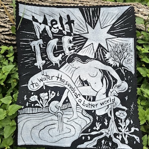 May include: Black and white linocut print depicting a woman pouring water, with the words "Melt Ice to water the seeds of a better world." The art includes a star, flowers, and a tree, with a raw, textured edge.