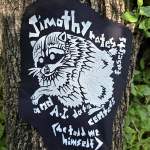 Parche impreso a mano con el lema "Jimothy odia a los fascistas y a los centros de datos de IA"