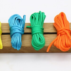 May include: Six spools of colorful paracord in white, yellow, blue, green, orange, and red.