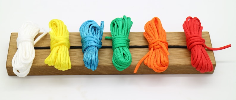 May include: Six spools of colorful paracord in white, yellow, blue, green, orange, and red.