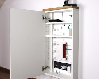 May include: White cabinet with a mirrored door, open to reveal shelves with a router, modem, and other electronics. The cabinet has a wood top and a pegboard back.