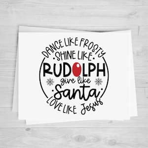 May include: A white card with black text in a circle that reads "Dance like Frosty, Shine like Rudolph, Give like Santa, Love like Jesus". The circle has a red nose in the center.