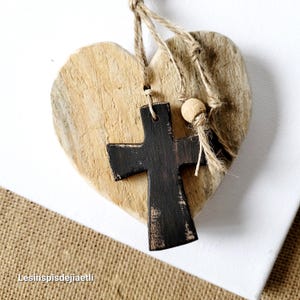 Large rustic wooden heart with small black wooden cross. Gift, religious object, decoration made from reclaimed wood.