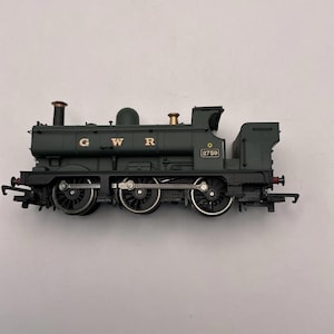 May include: Dark green model train locomotive with gold accents. The model has three sets of wheels and the letters "GWR" in gold. The number "2759" is visible on the side. The model has two smokestacks and a small bell.