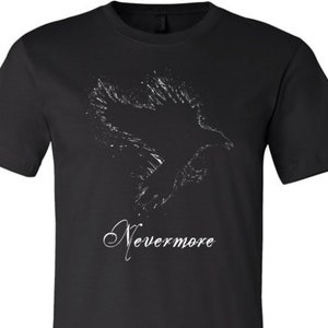 Puede incluir: Camiseta negra con una silueta blanca de un cuervo en vuelo y el texto "Nevermore" impreso en la parte delantera.