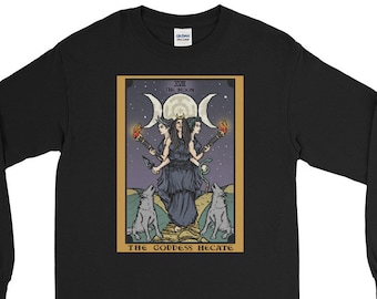 Pode incluir: Camiseta preta de manga comprida com um design de carta de tarô que apresenta uma figura de deusa tripla com três luas e dois lobos. O texto na carta diz "XXI THE MOON THE GODDESS HECATE".