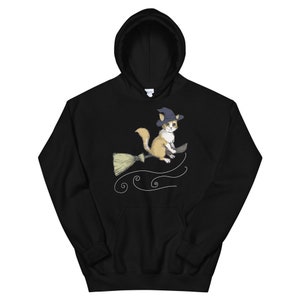 Pode incluir: Camisola de capuz preta com um gr&aacute;fico de um gato usando um chap&eacute;u de bruxa e montando uma vassoura. O gato est&aacute; voando pelo ar com vento girat&oacute;rio atr&aacute;s dele.