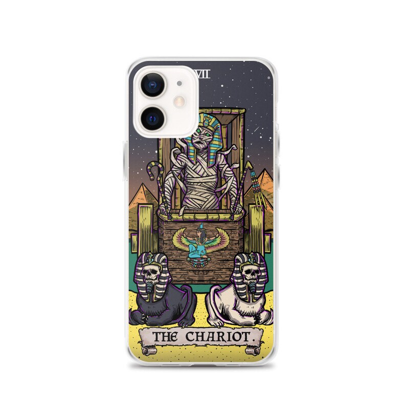 K&ouml;nnte beinhalten: Eine Handyh&uuml;lle mit einer farbenfrohen Illustration der Chariot-Karte aus einem Tarot-Deck. Die Karte zeigt eine mumienartige Figur in einem Wagen, der von zwei sphinxartigen Kreaturen gezogen wird. Die Karte ist vor einem sternenklaren Nachthimmel mit Pyramiden im Hintergrund platziert. Der Text "THE CHARIOT" ist am unteren Rand der Karte gedruckt.