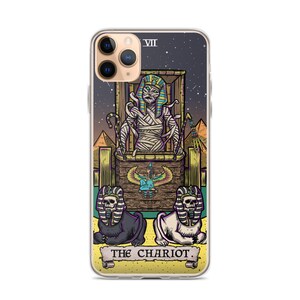 K&ouml;nnte beinhalten: Eine transparente Handyh&uuml;lle mit einer farbenfrohen Illustration der Chariot-Karte aus dem Tarot-Deck. Die Karte zeigt eine mumienartige Figur in einem Wagen, der von zwei sphinxartigen Kreaturen gezogen wird. Die Karte ist vor einem sternenklaren Nachthimmel platziert und der Text "THE CHARIOT" ist unten aufgedruckt.
