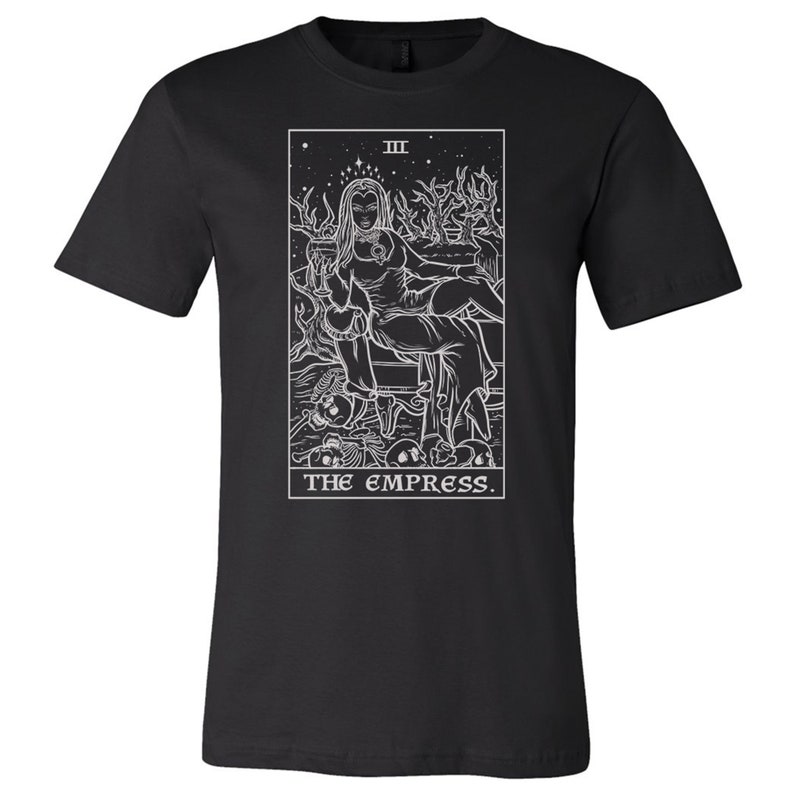 May include: Black t-shirt with a white outline of the Empress tarot card. The card features a woman sitting on a throne with a crown and a star above her head. The text "III THE EMPRESS." is below the image.