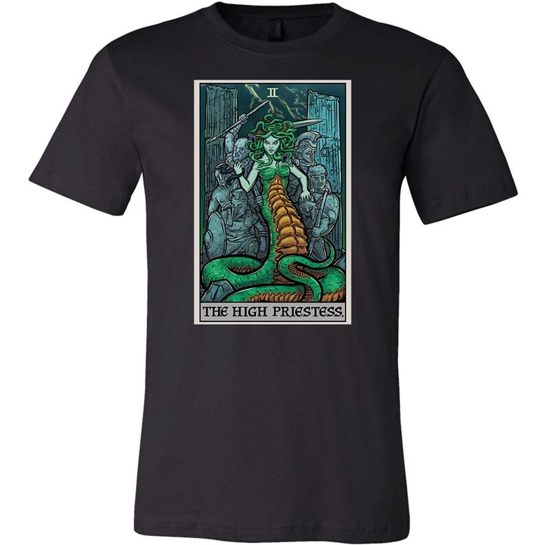 May include: Black t-shirt with a graphic of the High Priestess tarot card featuring a woman with a snake body and a crown. The card is surrounded by a border with the text "The High Priestess" and the Roman numeral "II".