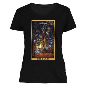 May include: A black t-shirt with a colorful illustration of Baba Yaga, a witch from Slavic folklore, holding a lantern and a broom. The illustration is surrounded by a gold frame and includes the text "IX THE HERMIT" and "BABA YAGA".