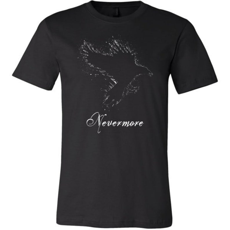Puede incluir: Camiseta negra con una silueta blanca de un cuervo en vuelo y el texto "Nevermore" impreso en la parte delantera.