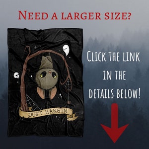 Pu&ograve; includere: Una coperta in pile nero con un simpatico pipistrello dei cartoni animati appeso a un ramo d'albero. Il pipistrello ha occhi grandi e un'espressione amichevole. Il testo "JUST HANGIN'" &egrave; scritto su uno striscione sotto il pipistrello.