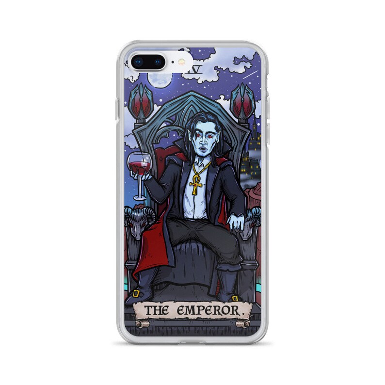 May include: A phone case featuring a colourful illustration of a vampire seated on a throne, holding a glass of wine. The illustration is in the style of a tarot card and includes the text "THE EMPEROR."