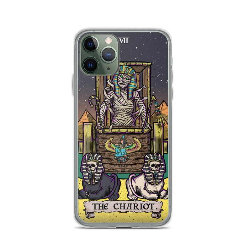K&ouml;nnte beinhalten: Eine transparente Handyh&uuml;lle mit einer farbenfrohen Illustration der Chariot-Karte aus dem Tarot-Deck. Die Karte zeigt eine mumienartige Figur in einem Wagen, der von zwei sphinxartigen Kreaturen gezogen wird. Die Karte ist vor einem sternenklaren Nachthimmel mit Pyramiden im Hintergrund platziert. Der Text "THE CHARIOT" ist am unteren Rand der Karte gedruckt.
