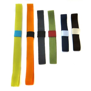 May include: Seven colourful elastic bands with different coloured accents. The bands are made of a woven material and are approximately 10 inches long.