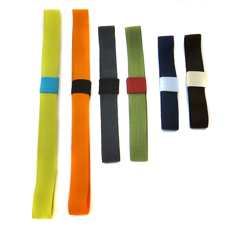 May include: Seven colourful elastic bands with different coloured accents. The bands are made of a woven material and are approximately 10 inches long.