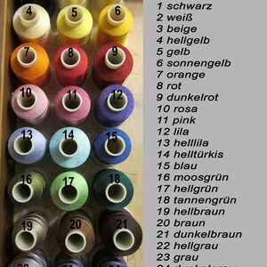 May include: A color chart of 24 spools of thread, numbered 1 through 24. The spools are arranged in four rows of six spools each. The colors include black, white, beige, yellow, orange, red, pink, blue, green, brown, and gray.