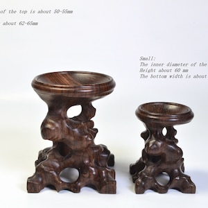 Op de afbeelding: Twee houten display stands, een grote en een kleine, met ingewikkelde houtsnijwerk. De grote stand is ongeveer 20 cm hoog en de kleine stand is ongeveer 15 cm hoog.