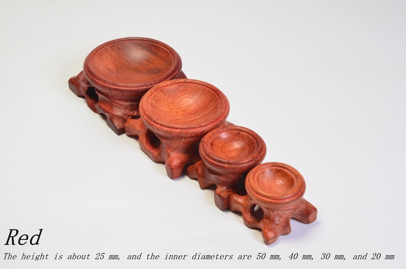 Op de afbeelding: Vijf houten display stands in verschillende maten, vari&euml;rend van 20 mm tot 50 mm in diameter. De stands zijn gemaakt van rood hout en hebben een gladde, gepolijste afwerking.